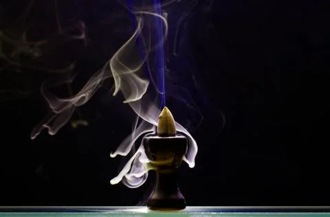 Aromatic cone smoldering in a ceramic stand Stock Photos