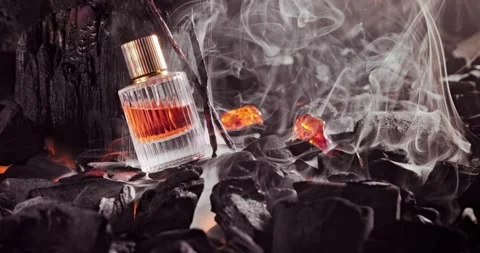 Aromatic incense perfume in translucent glass bottle on coal. Vidéo 333047379