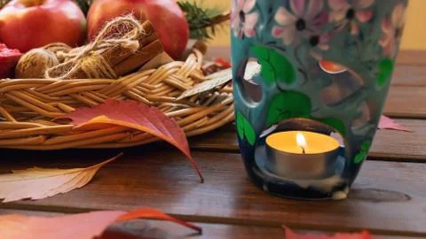 Aromatic lamp with candle on the background of a wicker basket with apples Stock Photos