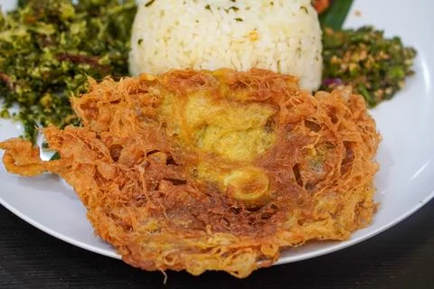 Aromatic lime leaf rice served with spicy stir-fried chicken skin Stock Photos