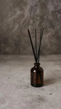 Aromatic reed diffuser bottle with black sticks on a dark marble background Stock Photos