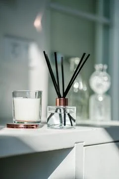 An aromatic reed diffuser stands on a table against a blurry background. Stock Photos