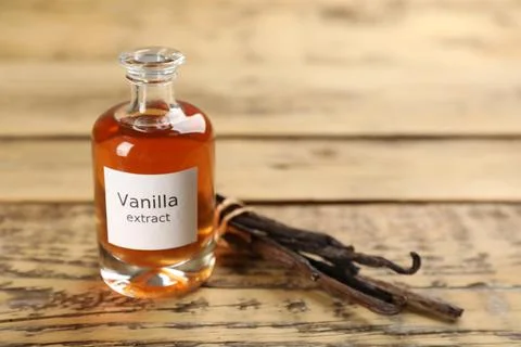 Aromatic vanilla extract and beans on wooden table, space for text Stock Photos