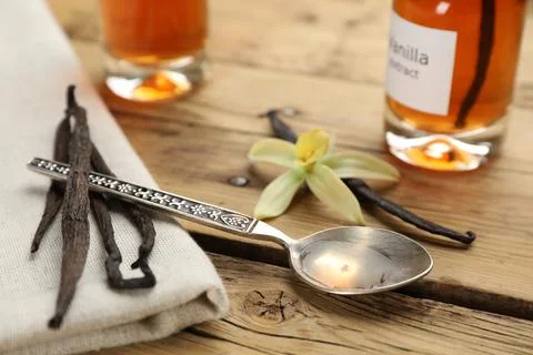 Aromatic vanilla extract and beans on wooden table Stock Photos