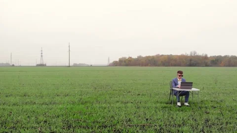 Around drone fly view of young man working remotely with laptop outside alone Stock Footage 171547804