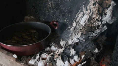 Around stuffed grape leaves in a pan on a woodfire at fireplace Stock Footage 122695873