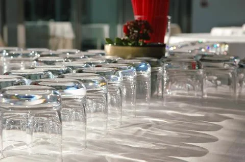 Arranged empty glasses on the table with white cloth in restaurant Stock Photos