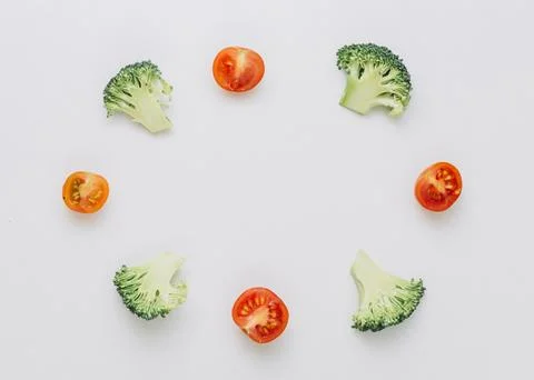 Arranged halved broccoli cherry tomatoes circular frame isolated white back.. Stock Photos