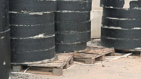 Arrangement of barrels stacked on pallets in a storage area. The barrels are Stock Footage 344675978