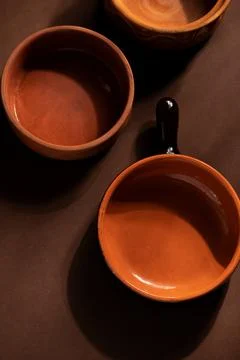 Arrangement of ceramic plates on brown background. Earthenware pottery objects,  Stock Photos