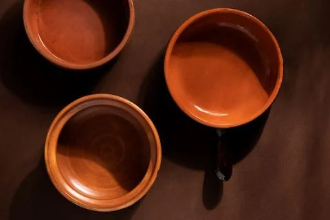 Arrangement of ceramic plates on brown background. Earthenware pottery objects,  Stock Photos