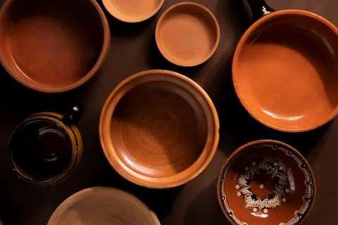 Arrangement of ceramic plates on brown background. Earthenware pottery objects,  Stock Photos