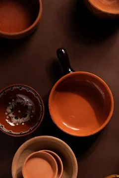 Arrangement of ceramic plates on brown background. Earthenware pottery objects,  Stock Photos