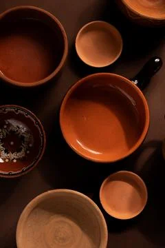 Arrangement of ceramic plates on brown background. Earthenware pottery objects,  Stock Photos