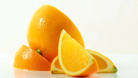 An arrangement of orange slices on a white surface slowly rotating Stock Footage 87857314