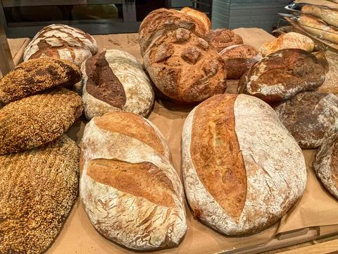 Arrangement of various bread loaves on a table, showcasing texture and colo.. Stock Photos