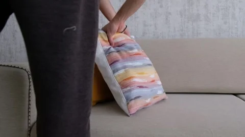 Arranging Cushions on Sofa with Hands in Cozy Living Room Stock Footage 304372903