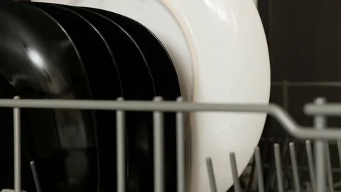 Arranging dishware inside built-in dishwasher Stock Footage 78669903