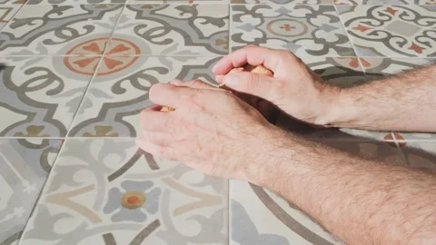 Arranging dried figs on patterned ceramic tiles for sun drying. Medium closeup Stock Footage 346152124