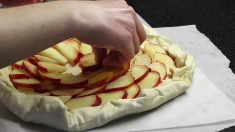 Arranging fresh nectarine slices into geometric pattern on pie dough Stock Footage 336848371