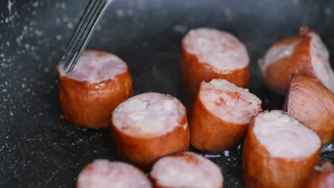 Arranging frying sausage with fork and closing pan lid Vídeos de archivo 341088533