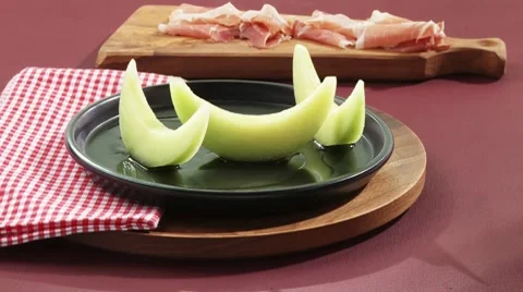 Arranging melon and Parma ham on a plate Vídeos de archivo 8570872