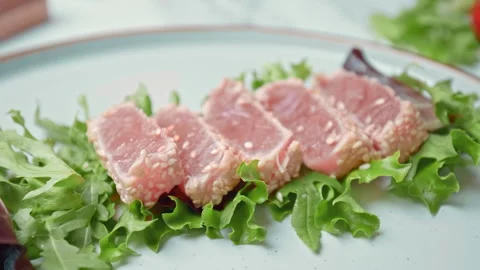 Arranging in a serving plate Seared Tuna with decorative vegetables in 4K. Stock Footage 141310837