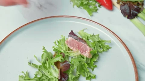 Arranging in a serving plate Seared Tuna with decorative vegetables in 4K. Stock Footage 141310928