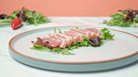 Arranging in a serving plate Seared Tuna with decorative vegetables in 4K. Stock Footage 141310943