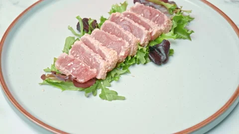 Arranging in a serving plate Seared Tuna with decorative vegetables in 4K. Stock Footage 141311020