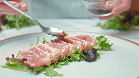 Arranging in a serving plate Seared Tuna with decorative vegetables in 4K. Stock Footage 141311252