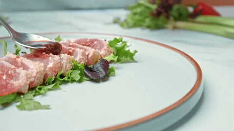Arranging in a serving plate Seared Tuna with decorative vegetables in 4K. Stock Footage 141311620