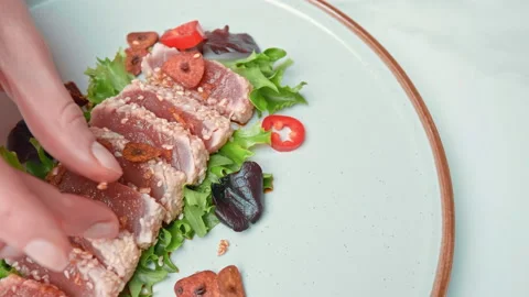 Arranging in a serving plate Seared Tuna with decorative vegetables in 4K. Stock Footage 141312978
