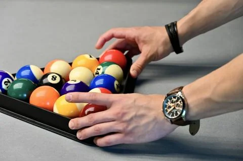 Arranging a triangle rack of billiard balls on a pool table 写真素材