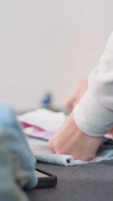 Arranging vibrant fabric samples for design evaluation, Hands meticulously Stock Footage 329479643