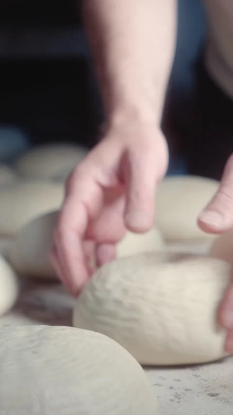 Arranging white bread dough pieces on a baking board Video stock 344312931