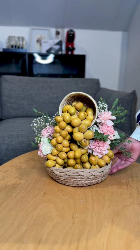 Arranging Yellow Dates And Flowers In Woven Basket Stock Footage 344548959