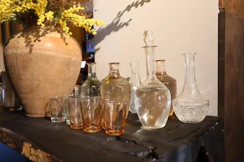 An array of assorted glassware and decorative items placed elegantly on a rustic Stock Photos