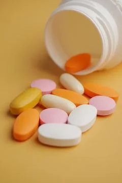 An Array of Assorted Vitamins and Medications Displayed on a Bright Yellow Foto stock