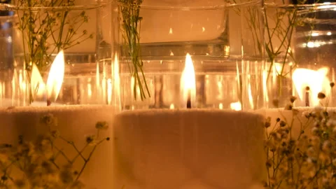 An array of beautifully arranged candles surrounded by delicate flowers Stock Footage 326958091