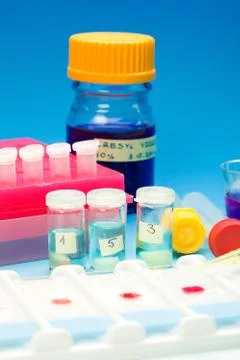 Array of blood samples for microscopy and biopsy tissue on blue Stock Photos
