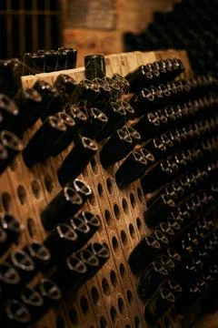 Array of bottles of wine neatly arranged in a classic wine cellar. Stock Photos