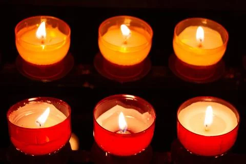 Array of candles or tealights in church with red exterior Stock Photos