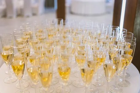 Array of champagne flutes are neatly stacked on a table, ready to be enjoyed Foto stock