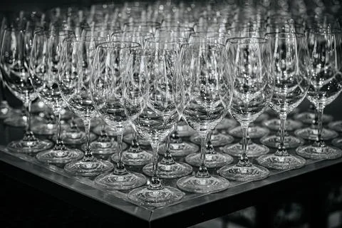 Array of clear glass wine glasses arranged in a neat grid pattern on a refl.. Stock Photos