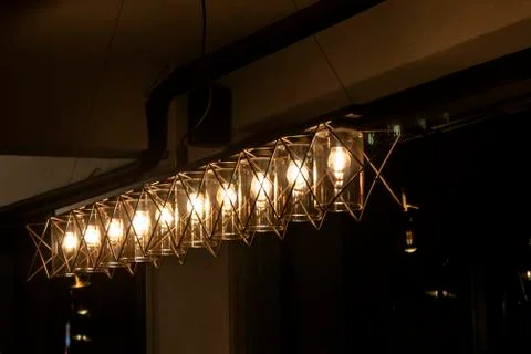 Array of clear light chandeliers under dark atmosphere Stock Photos