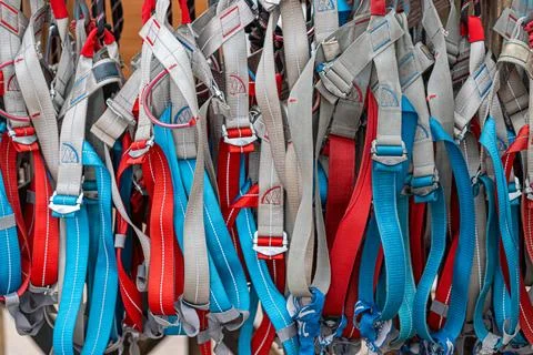 Array of climbing harnesses in outdoor gear setup Stock Photos