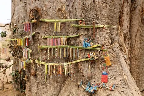 Array of colorful artisanal crafts hang from the branches of a tree, suspended f 스톡 사진