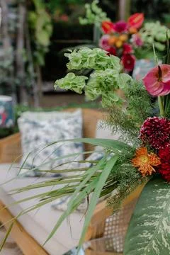Array of colorful blooms arranged pleasingly beside a classic looking chair and Foto stock