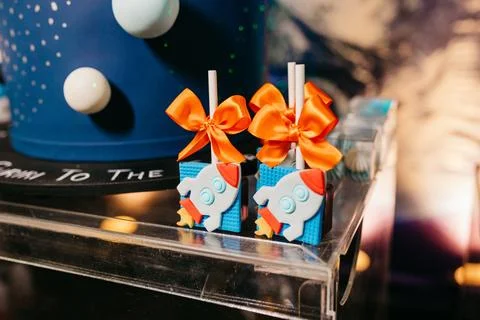 Array of colorful cake pops with rocket designs on a countertop Stock Photos